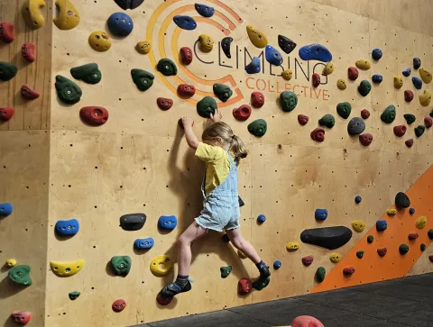 A child traverses the children's bouldering wall at ChalkUp in Somerset