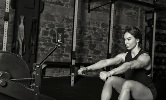 Female athlete rows on a Concept 2 row erg