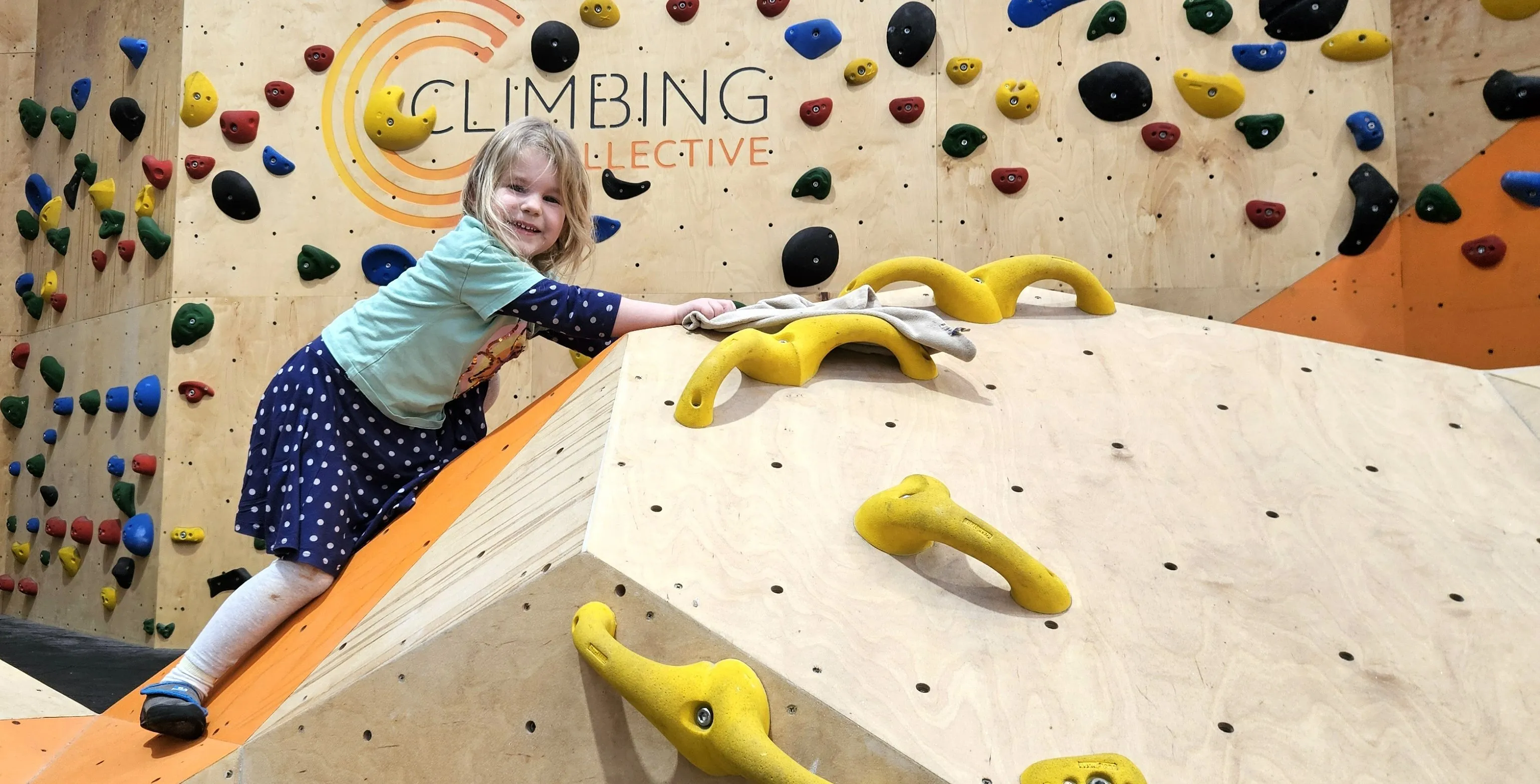 A child climbs on our dedicated children's bouldering wall at ChalkUp